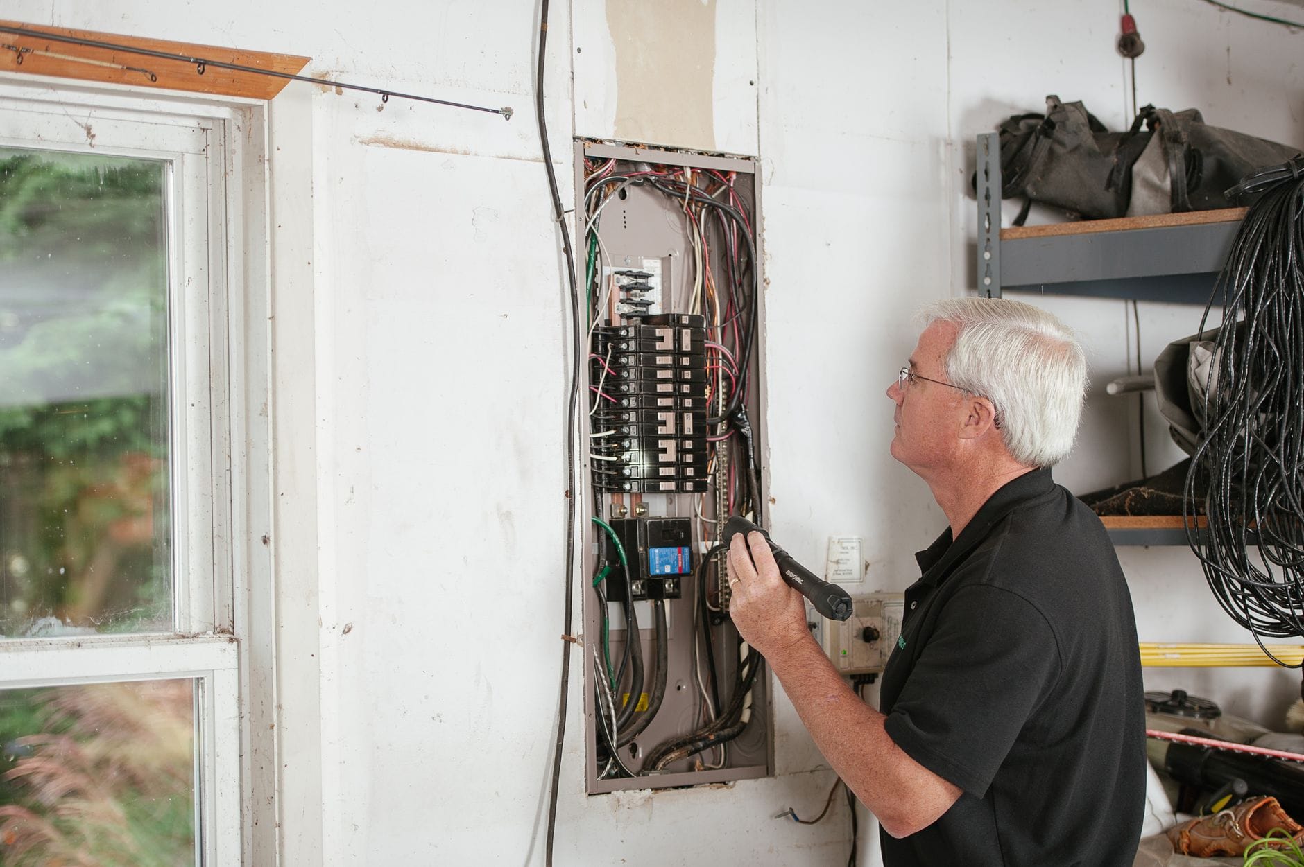 Najczęstsze błędy w domowych instalacjach elektrycznych i jak ich uniknąć Elektryk sprawdza domową rozdzielnicę, dbając o bezpieczeństwo instalacji